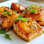 - 450 g Lachsfilet, ohne Haut, in mundgerechte Würfel geschnitten - 60 ml Honig - 45 ml Sojasauce (geringer Natriumgehalt, wenn gewünscht) - 3 Knoblauchzehen, fein gehackt - 1 Esslöffel frischer Ingwer, gerieben - 30 ml Olivenöl - 1 Esslöffel Sesamsamen (optional) - 2 Frühlingszwiebeln, in Ringe geschnitten (zum Garnieren) - Salz und Pfeffer nach Geschmack Ich empfehle, frische Zutaten zu verwenden. Frischer Lachs gibt den besten Geschmack. Lagern Sie den Lachs im Kühlschrank und verwenden Sie ihn innerhalb von zwei Tagen. Knoblauch und Ingwer können Sie ebenfalls frisch reiben und hacken. Sie bringen mehr Aroma in das Gericht. Halten Sie alle Zutaten bereit, um den Kochprozess zu erleichtern. Wenn Sie keinen Lachs mögen, probieren Sie Hähnchenbrust oder Tofu. Diese funktionieren gut in der Marinade. Für den Honig können Sie Agavendicksaft oder Ahornsirup verwenden. Sojasauce lässt sich durch Kokosnussaminos oder Tamari ersetzen. Nutzen Sie Olivenöl oder Erdnussöl, je nach Geschmack. {{ingredient_image_2}} Um die Honig-Knoblauch glasierte Lachs Häppchen zuzubereiten, marinieren Sie die Lachswürfel in einer Mischung aus Honig, Sojasauce, Knoblauch und Ingwer. Dann braten Sie die Stücke goldbraun und servieren sie mit der eingedickten Marinade. 1. Marinade anrühren: Nehmen Sie eine mittelgroße Schüssel. Geben Sie 60 ml Honig, 45 ml Sojasauce, 3 fein gehackte Knoblauchzehen und 1 Esslöffel geriebenen Ingwer hinein. Rühren Sie alles gut durch. 2. Lachs marinieren: Fügen Sie 450 g gewürfelten Lachs hinzu. Vermengen Sie ihn sanft, sodass alle Stücke gut bedeckt sind. Lassen Sie die Marinade 15 bis 20 Minuten bei Raumtemperatur einziehen. 3. Öl erhitzen: Erhitzen Sie 30 ml Olivenöl in einer großen Pfanne bei mittlerer bis hoher Hitze. 4. Lachs anbraten: Nehmen Sie die Lachsstücke aus der Marinade (bewahren Sie die Marinade auf) und legen Sie sie in die Pfanne. Braten Sie den Lachs 2 bis 3 Minuten auf jeder Seite, bis er goldbraun ist. 5. Marinade eindicken: Gießen Sie die reservierte Marinade in die Pfanne. Lassen Sie sie 2 bis 3 Minuten kochen, bis sie leicht eindickt. 6. Anrichten: Nehmen Sie die Pfanne vom Herd. Streuen Sie nach Wunsch Sesamsamen darüber und garnieren Sie mit geschnittenen Frühlingszwiebeln. - Achten Sie darauf, die Pfanne nicht zu überfüllen. Arbeiten Sie in Chargen, wenn nötig. - Prüfen Sie den Lachs nach 2 bis 3 Minuten. Er sollte goldbraun und durchgegart sein. - Verwenden Sie frische Zutaten für den besten Geschmack. Ein häufiger Fehler ist, den Lachs zu lange in der Marinade zu lassen. 20 Minuten reichen aus. Zu langes Marinieren kann den Fisch zäh machen. Ein weiterer Fehler ist, die Pfanne zu überfüllen. Wenn das passiert, gart der Lachs nicht gleichmäßig. Braten Sie die Häppchen in kleinen Portionen, um beste Ergebnisse zu erzielen. Achten Sie auch auf die Hitze. Zu hohe Hitze kann den Lachs außen verbrennen, während er innen roh bleibt. Sie können das Rezept leicht anpassen. Fügen Sie etwas scharfen Chili oder Cayennepfeffer zur Marinade hinzu, wenn Sie es scharf mögen. Für eine fruchtige Note probieren Sie Ananassaft oder Limettensaft. Diese Fette können Sie auch als Marinade verwenden: Erdnussöl oder Avocadoöl. Beide bringen neue Geschmäcker. Wenn Sie es süßer mögen, fügen Sie mehr Honig hinzu. Experimentieren Sie und finden Sie Ihre perfekte Mischung. Servieren Sie die Lachs Häppchen auf einem großen, flachen Teller. Garnieren Sie sie mit Frühlingszwiebeln und Sesamsamen für einen schönen Look. Stellen Sie eine kleine Schale mit der restlichen Marinade zum Dippen bereit. Das macht das Essen noch besser. Denken Sie daran, den Lachs warm zu halten, bis Sie ihn servieren. So bleibt er saftig und lecker. Pro Tipps Marinieren für mehr Geschmack: Lassen Sie die Lachswürfel mindestens 20 Minuten in der Marinade ziehen, um die Aromen voll auszuloten. Die richtige Hitze: Achten Sie darauf, dass das Öl in der Pfanne heiß genug ist, bevor Sie den Lachs hinzufügen, um eine schöne Kruste zu erzielen. Gleichmäßiges Garen: Überfüllen Sie die Pfanne nicht mit Lachs, damit jedes Stück gleichmäßig gart und nicht dampft. Serviertipps: Garnieren Sie die Häppchen mit frischen Frühlingszwiebeln und Sesamsamen für zusätzlichen Crunch und Farbe. {{image_4}} Für einen leckeren Auflauf kannst du die Lachshäppchen leicht abwandeln. Mische die Lachsstücke mit etwas gekochtem Gemüse wie Brokkoli oder Spinat. Füge die Marinade hinzu und lege alles in eine Auflaufform. Überbacke das Ganze mit Käse für einen schönen Geschmack. So hast du ein herzhaftes Gericht, das die ganze Familie lieben wird. Die gegrillte Variante bringt ein tolles Aroma. Du kannst die marinierten Lachsstücke auf Spieße stecken und sie auf dem Grill garen. Achte darauf, sie regelmäßig zu wenden, damit sie gleichmäßig bräunen. Diese Version hat einen rauchigen Geschmack, der wunderbar zu den süßen und herzhaften Aromen passt. Wenn du eine pflanzliche Option suchst, kann Tofu eine tolle Wahl sein. Schneide den Tofu in Würfel und mariniere ihn wie den Lachs. Brate die Tofuwürfel in der Pfanne oder grille sie. Du kannst auch Tempeh oder Seitan verwenden, um verschiedene Texturen und Geschmäcker zu genießen. Diese Varianten sind gesund und bieten viele Möglichkeiten. Um die Reste der Honig-Knoblauch glasierte Lachs Häppchen gut zu lagern, lege sie in einen luftdichten Behälter. Achte darauf, dass der Behälter gut verschlossen ist. So bleiben die Häppchen frisch und lecker. Du kannst sie bis zu drei Tage im Kühlschrank aufbewahren. Wenn du die Häppchen länger aufbewahren willst, friere sie ein. Lege sie auf ein Backblech und stelle sie ins Gefrierfach. Nach ein paar Stunden kannst du sie in einen Gefrierbeutel umfüllen. So kleben sie nicht zusammen. Zum Auftauen lege sie einfach über Nacht in den Kühlschrank. Die Lachshäppchen sind bis zu drei Tage im Kühlschrank haltbar. Achte darauf, sie gut verpackt zu lagern. Wenn sie unangenehm riechen oder die Farbe sich ändert, wirf sie weg. Sicherheit geht vor! Die Marinade hält sich gut im Kühlschrank. Sie bleibt frisch für etwa 3 bis 5 Tage. Bewahren Sie sie in einem luftdichten Behälter auf. Das sorgt dafür, dass die Aromen nicht verloren gehen. Vor der Nutzung sollten Sie die Marinade gut umrühren. So vermischen sich die Zutaten wieder. Ja, Sie können dieses Rezept für viele andere Fische verwenden. Zum Beispiel sind Forelle und Kabeljau gute Alternativen. Achten Sie darauf, die Garzeit anzupassen. Dünnere Fische benötigen weniger Zeit. Dickere Fische brauchen vielleicht etwas länger. Die Marinade wird auch in diesen Fällen gut schmecken. Um die Lachs Häppchen aufzuwärmen, nutzen Sie eine Pfanne. Erhitzen Sie die Pfanne bei mittlerer Hitze. Fügen Sie ein wenig Öl hinzu, um ein Anhaften zu verhindern. Legen Sie die Häppchen in die Pfanne und erwärmen Sie sie für etwa 2-3 Minuten. Drehen Sie sie einmal um, damit sie gleichmäßig warm werden. So bleibt der Lachs saftig und lecker. In diesem Blogpost haben wir die Zutaten, die Zubereitung und die besten Tipps für Honig-Knoblauch glasierte Lachs Häppchen behandelt. Ich hoffe, du fühlst dich jetzt bereit, dieses leckere Gericht zuzubereiten. Denke an die Alternativen für die Zutaten und die Variationen, die du ausprobieren kannst. Vermeide häufige Fehler und achte auf die Lagerung der Reste. Mit diesen Informationen kannst du dein Kocherlebnis verbessern und deine Gäste beeindrucken. Viel Spaß beim Kochen!